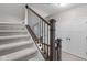 Carpeted staircase with decorative railings and natural light creates a welcoming and stylish transition between floors at 13245 E 131St St, Fishers, IN 46037