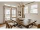 Bright dining room features a rustic wood table, elegant lighting, and access to the outdoors at 1395 Chatham Hills Blvd, Westfield, IN 46074