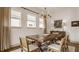 Elegant dining room with a wooden table, chandelier, and natural light from the windows at 1395 Chatham Hills Blvd, Westfield, IN 46074