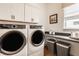 Functional laundry room featuring modern washer, dryer and counter with ample storage space at 1395 Chatham Hills Blvd, Westfield, IN 46074