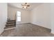 Bright bedroom with a staircase, window, and neutral carpeting at 1403 Lafayette Ave, Columbus, IN 47201