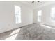 Bright bedroom featuring neutral carpet, white walls, three windows offering ample natural light, and a ceiling fan at 1403 Lafayette Ave, Columbus, IN 47201