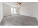 Bright bedroom featuring neutral carpet, white walls, two windows offering ample natural light, ceiling fan, and a door to closet at 1403 Lafayette Ave, Columbus, IN 47201