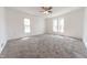 Bright bedroom featuring neutral carpet, white walls, three windows offering ample natural light, and a ceiling fan at 1403 Lafayette Ave, Columbus, IN 47201