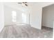 Bright bedroom featuring neutral carpet, white walls, three windows offering ample natural light, ceiling fan, and closet at 1403 Lafayette Ave, Columbus, IN 47201