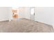 Open living space with neutral carpet, white walls, an adjacent kitchen, and a white door at 1403 Lafayette Ave, Columbus, IN 47201