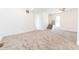 Spacious living room with neutral carpet, white walls, staircase, and bright light at 1403 Lafayette Ave, Columbus, IN 47201