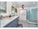 Bathroom featuring double sinks, a glass shower, modern lighting, and large window over a bench at 14720 Warner Trl, Westfield, IN 46074