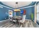 Elegant dining area with a modern chandelier, blue walls, and seating for six around a stylish gray table at 14720 Warner Trl, Westfield, IN 46074