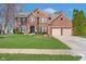 Charming two-story red brick home with a well-manicured lawn and a two car garage in a suburban neighborhood at 14720 Warner Trl, Westfield, IN 46074