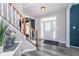 Inviting foyer featuring wood floors, a staircase with white railings, and a front door with decorative glass at 14720 Warner Trl, Westfield, IN 46074