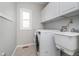Functional laundry room with white cabinetry, sink, and modern washer and dryer at 14720 Warner Trl, Westfield, IN 46074