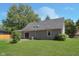 Spacious backyard showcases lush lawn and a gray home with sliding glass doors and mature trees at 1528 N Dukane Way, Indianapolis, IN 46214