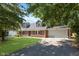 Traditional brick home with dormer windows, attached garage, and paved driveway at 1528 N Dukane Way, Indianapolis, IN 46214