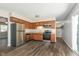 The updated kitchen features stainless steel appliances and warm wood cabinets at 1528 N Dukane Way, Indianapolis, IN 46214