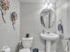 Well-lit bathroom with a pedestal sink, decorative mirror, and neutral decor at 16060 Barringer Ct, Westfield, IN 46074