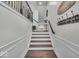 Elegant staircase with white wainscoting, wooden steps, and iron railing leading upstairs at 16060 Barringer Ct, Westfield, IN 46074