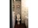 Small bathroom featuring a toilet, sink, dark wood floors, and vintage wallpaper at 1700 S Perdieu Rd, Muncie, IN 47302