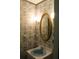 Small bathroom with a vanity sink, gold mirror and patterned wallpaper at 1700 S Perdieu Rd, Muncie, IN 47302