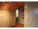 This secondary bedroom has wood-paneled walls, carpeted floor, and access to shelving and closet at 1700 S Perdieu Rd, Muncie, IN 47302