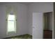 Bright bedroom with large window, hardwood floors, and open doorway to additional bedroom space at 1700 S Perdieu Rd, Muncie, IN 47302