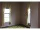 Bedroom features two windows with floral carpet and neutral walls and curtains at 1700 S Perdieu Rd, Muncie, IN 47302