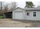 Exterior view of a detached garage and carport featuring an American flag door decoration at 1700 S Perdieu Rd, Muncie, IN 47302