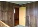 Hallway with wood-paneled walls providing access to other rooms in the house with carpeted floors at 1700 S Perdieu Rd, Muncie, IN 47302