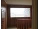 A wood-paneled hallway with staircase leading to a large window offering an abundance of natural light at 1700 S Perdieu Rd, Muncie, IN 47302