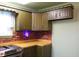The kitchen boasts wooden cabinets, a brick backsplash, laminate counters, and neutral accents at 1700 S Perdieu Rd, Muncie, IN 47302