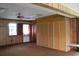 Living room featuring paneled walls, ceiling fan, and a closet with folding doors at 1700 S Perdieu Rd, Muncie, IN 47302