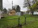 Spacious, fenced backyard featuring well-maintained lawn, shed, and play equipment for outdoor enjoyment at 1706 Manor Dr, Lebanon, IN 46052