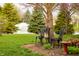 Picturesque backyard scene with a birdhouse, mature trees, and a lush green lawn at 172 Arabian Ct, Whiteland, IN 46184