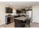 Modern kitchen features an island with granite countertops, dark cabinetry, and stainless steel appliances at 181 Kiawah Dr, Whiteland, IN 46184
