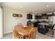 Inviting kitchen with dark cabinets, an island with seating, and a dining area at 181 Kiawah Dr, Whiteland, IN 46184