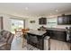 Open kitchen with a breakfast bar, granite countertops, and dark cabinetry at 181 Kiawah Dr, Whiteland, IN 46184