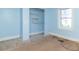 Bedroom featuring light blue walls, unfinished hardwood floors, closet, and a window at 218 Illinois St, Shirley, IN 47384
