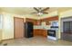 Well-lit kitchen with wooden cabinets, complete with black appliances and access to another room at 218 Illinois St, Shirley, IN 47384