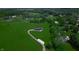 An aerial view shows a house on a large lot with long driveway surrounded by green grass at 2428 S Morgantown Rd, Greenwood, IN 46143