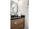 Elegant bathroom vanity with black countertop, wooden cabinets, and modern mirror and fixtures at 2428 S Morgantown Rd, Greenwood, IN 46143