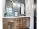 Charming bathroom vanity featuring natural wood cabinets, dual sinks, quartz countertops, and stylish light fixtures at 2428 S Morgantown Rd, Greenwood, IN 46143