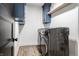 Convenient laundry room featuring modern, stainless steel washer and dryer units, storage cabinets, and stylish, plank flooring at 2428 S Morgantown Rd, Greenwood, IN 46143