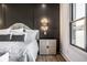 Close up of the main bedroom featuring a padded headboard, wooden night stand and wall sconces at 2428 S Morgantown Rd, Greenwood, IN 46143