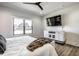 Spacious bedroom with wood floors, a TV, and a window overlooking the outdoor landscape at 2428 S Morgantown Rd, Greenwood, IN 46143