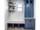 A well-designed mud room with custom blue cabinets, floating shelves and a built-in bench at 2428 S Morgantown Rd, Greenwood, IN 46143