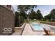 A modern backyard featuring a pool, fire bowls, manicured landscaping, and patio furniture at 2428 S Morgantown Rd, Greenwood, IN 46143