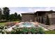 Landscaped backyard with a pool, fire bowls, patio, and lush plants and grass at 2428 S Morgantown Rd, Greenwood, IN 46143