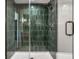Walk in shower with green tile surround, rainfall shower head and glass door at 2428 S Morgantown Rd, Greenwood, IN 46143