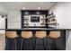 Home wet bar with seating, dark cabinets, granite countertop, beverage cooler, floating shelves, and TV at 2428 S Morgantown Rd, Greenwood, IN 46143