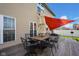 Inviting back deck featuring a shade sail, outdoor dining set, and a tranquil space for relaxing and entertaining at 2468 Wyndham S Pl, Columbus, IN 47203